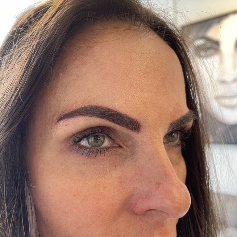 Woman's face with new eyebrow tattoo.